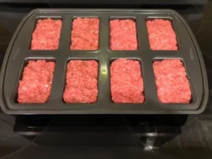 Delicious mini meatloafs served on a plate with herbs