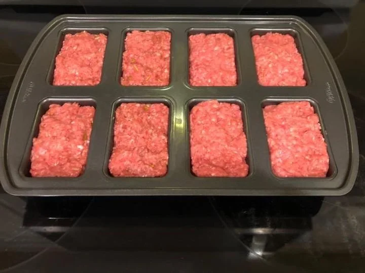 Delicious mini meatloafs served on a plate with herbs