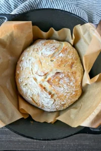 Freshly baked no knead artisan bread loaf on a wooden table