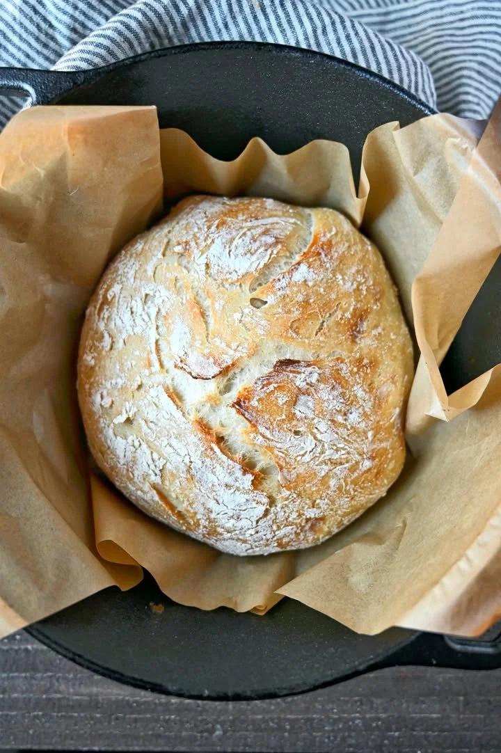Freshly baked no knead artisan bread loaf on a wooden table