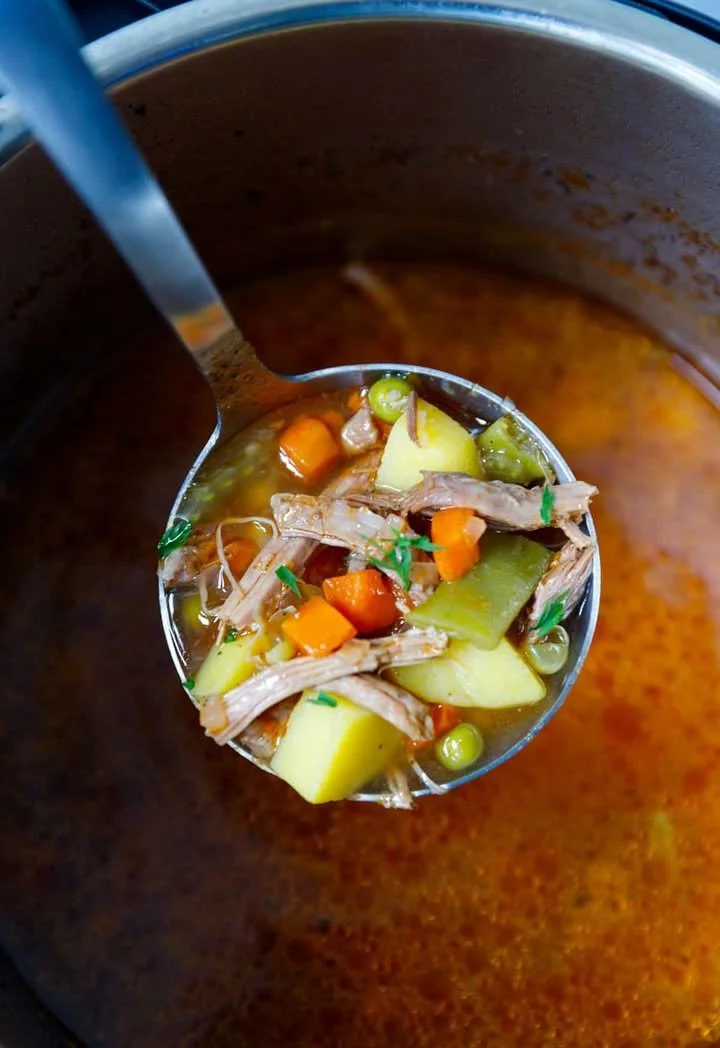 Bowl of Old Fashioned Beef and Vegetable Soup with fresh vegetables and herbs