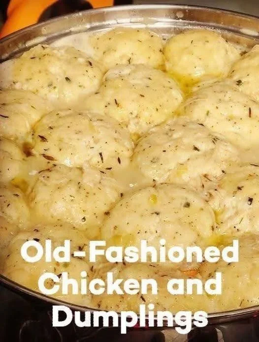Bowl of old-fashioned chicken and dumplings garnished with herbs.
