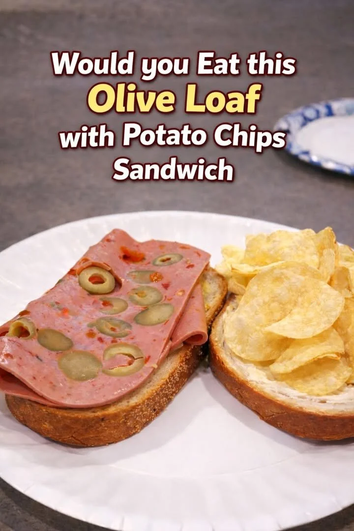 Olive loaf sandwich served with crispy potato chips on a plate.