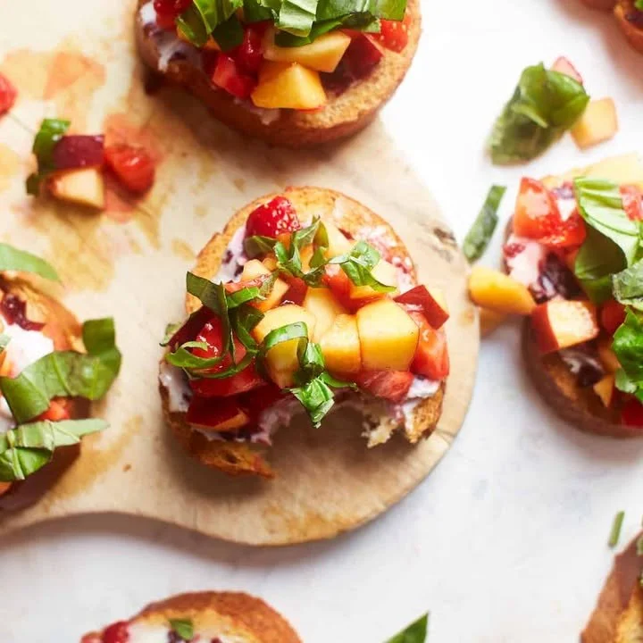 Delicious Peach and Strawberry Fruit Bruschetta topped with fresh mint.