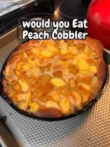 Delicious homemade peach cobbler served warm with vanilla ice cream