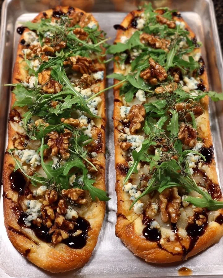 Delicious Pear & Gorgonzola flatbread with arugula, candied walnuts, and fig-balsamic reduction