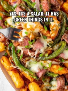 Philly cheesesteak loaded fries topped with melted cheese and fresh ingredients