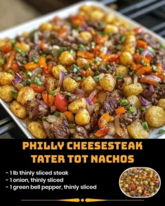 Philly cheesesteak tater tot nachos topped with melted cheese and green onions.