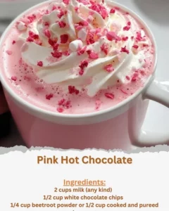 Delicious pink hot chocolate topped with whipped cream and sprinkles in a mug.