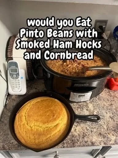Bowl of pinto beans with smoked ham hocks and a side of cornbread