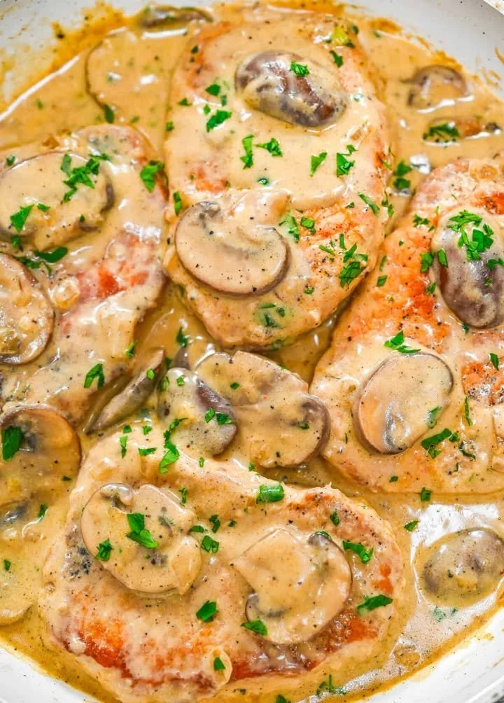 Pork loin chops served with savory mushroom sauce on a plate