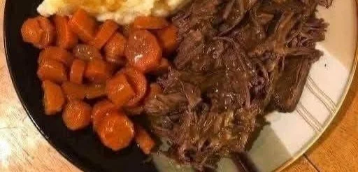 Delicious pot roast served with carrots, mashed potatoes, and gravy