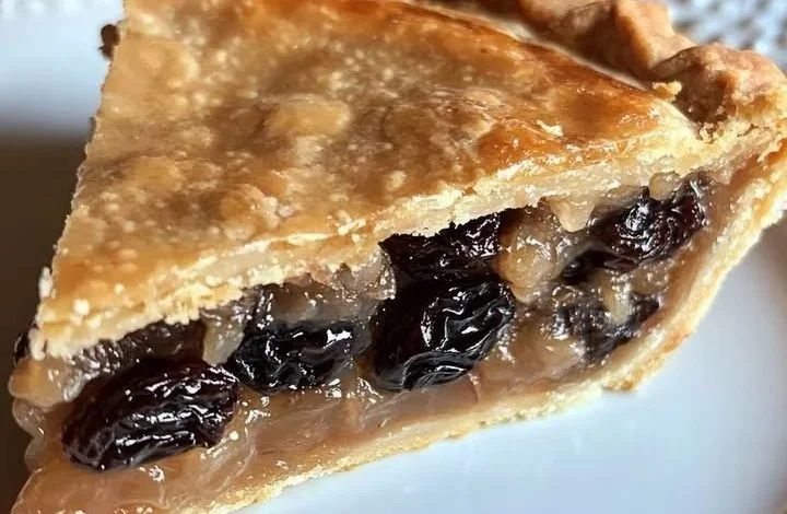 A delicious homemade raisin pie served on a rustic wooden table.
