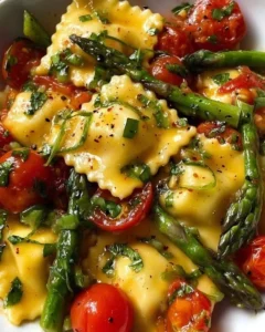 Plate of ravioli with tomatoes, asparagus, garlic, and herbs