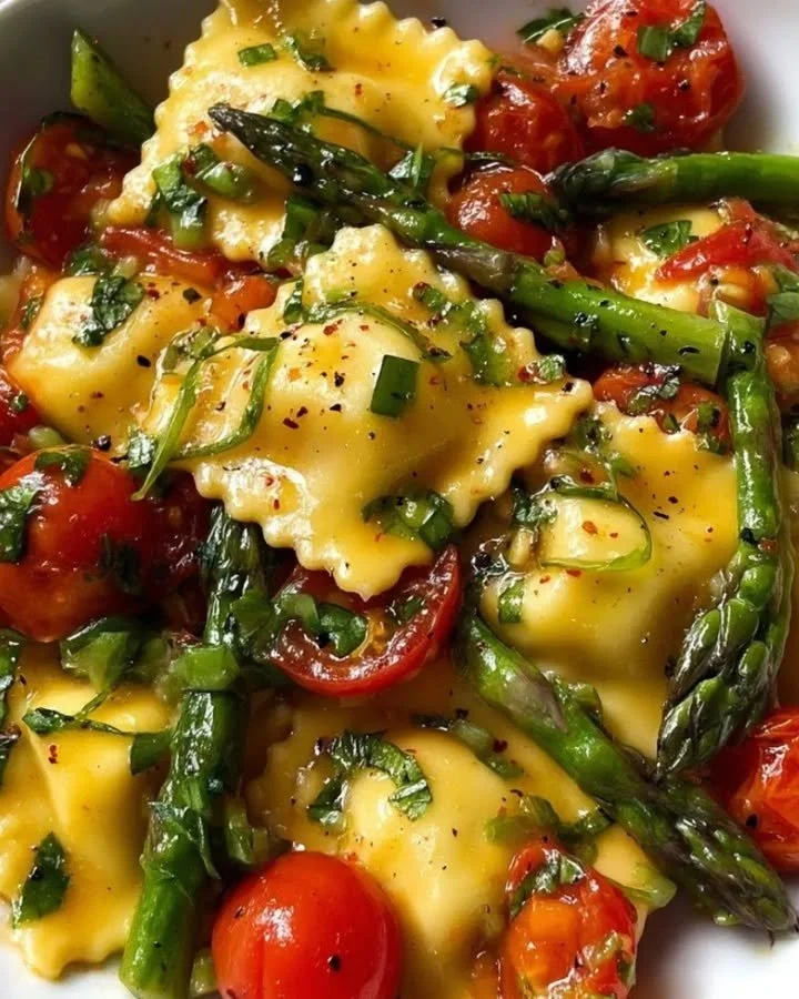 Plate of ravioli with tomatoes, asparagus, garlic, and herbs