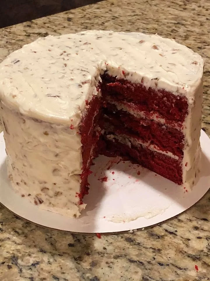 Deliciously decorated Real Deal Red Velvet Cake on a rustic wooden table