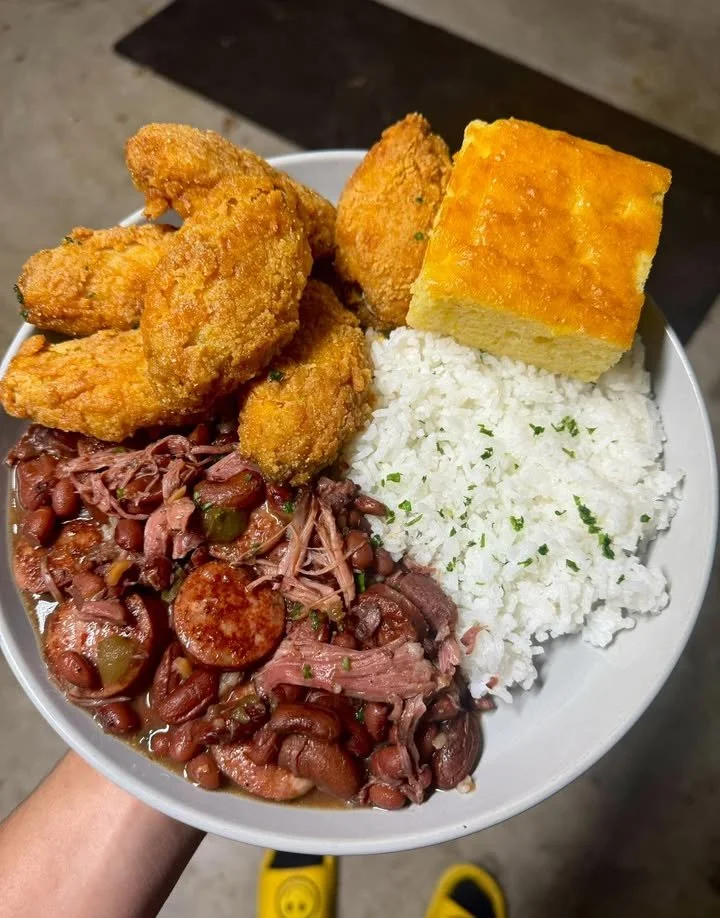 Plate of red beans and rice served with fried chicken wings and cornbread