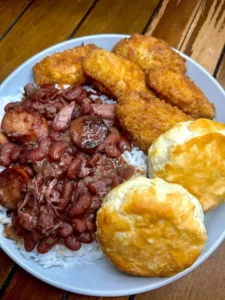 Plate of red beans and rice served with fried chicken wings
