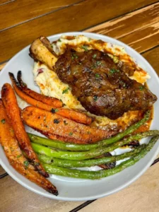 Red wine braised lamb shank with creamy Asiago mashed potatoes on a plate.
