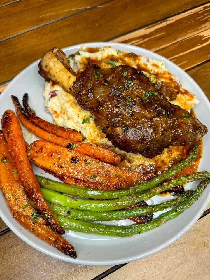 Red wine braised lamb shank with creamy Asiago mashed potatoes on a plate.