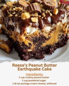 Slice of Reese's Peanut Butter Earthquake Cake topped with peanut butter and chocolate.