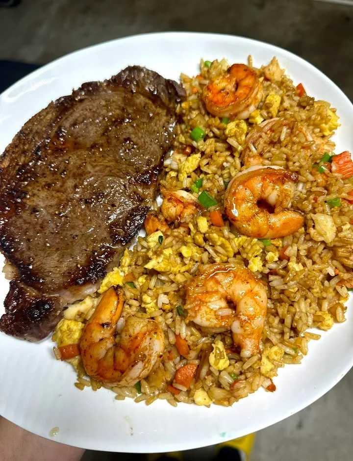 Ribeye steak served with shrimp and crab fried rice on a plate