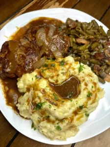 Delicious Salisbury steak dinner with gravy and sides on a plate