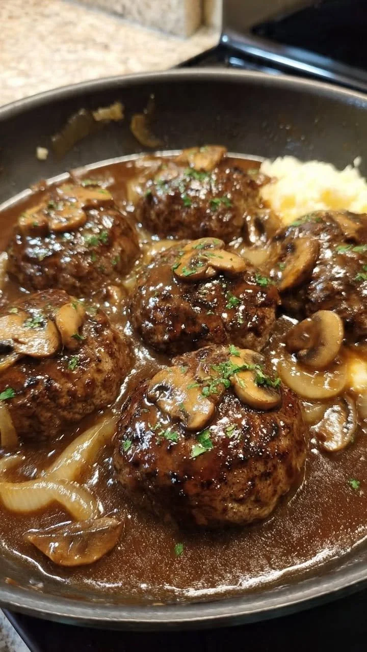 Salisbury steak with garlic mashed potatoes and mushroom onion gravy on a plate