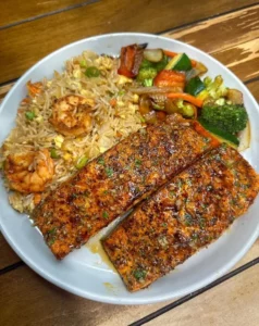 Delicious Salmon and Shrimp Fried Rice served in a bowl with fresh vegetables