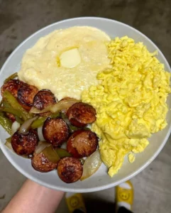 Delicious Sausage and Peppers served with grits and scrambled eggs