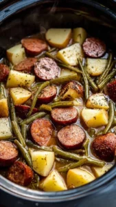 Sausage and potatoes dish served with green beans on a plate