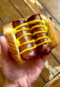 Delicious sausage served with mustard on a plate