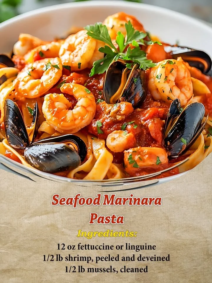 A bowl of seafood marinara pasta with shrimp, mussels, and fresh herbs.
