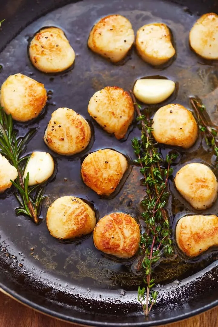 Deliciously seared scallops served with a creamy sauce and fresh herbs
