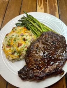 A delicious simple steak dinner served with sides.