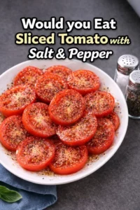 Fresh sliced tomato seasoned with salt and pepper on a plate