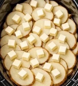 Slow cooker cheesy potatoes topped with cheese and herbs