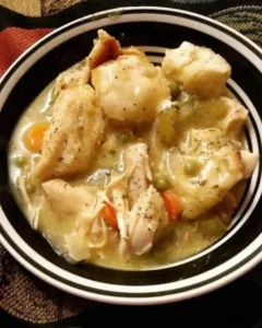 Bowl of slow cooker chicken and dumplings garnished with parsley