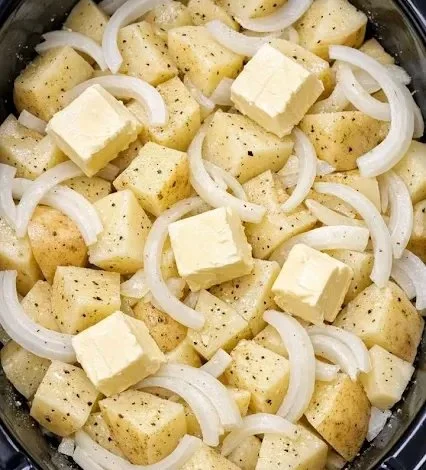 Bowl of slow cooker creamy garlic mashed potatoes garnished with herbs.