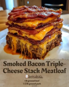 Smoked Bacon Triple-Cheese Stack Meatloaf on a plate garnished with herbs