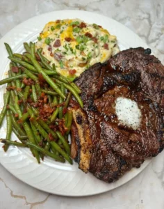 Delicious smoked ribeye steak with loaded mashed potatoes and green beans