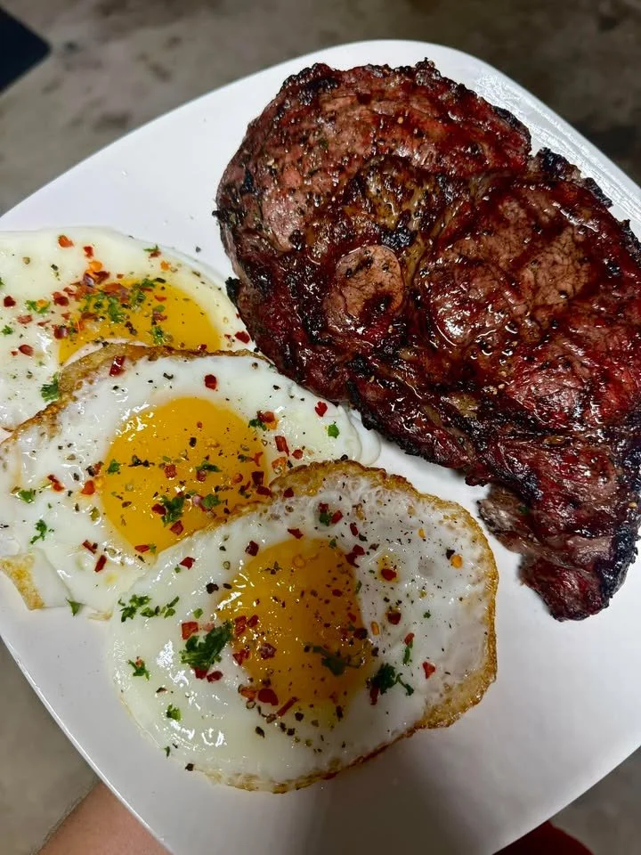 Smoked ribeye steak served with fried eggs on a plate