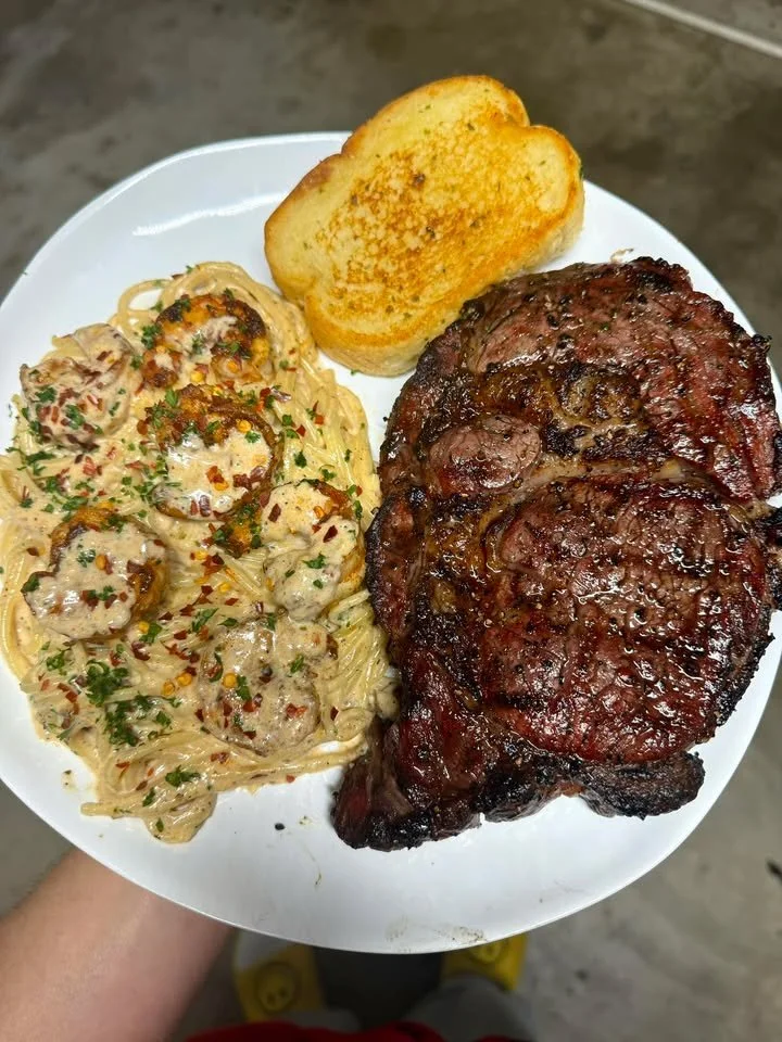 Delicious smoked ribeye served with cajun shrimp pasta and garlic toast
