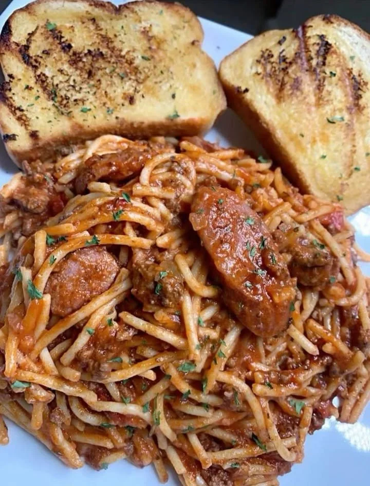 A plate of spaghetti topped with marinara sauce and fresh basil.