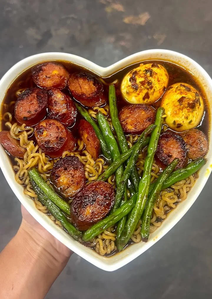 A delicious bowl of ramen featuring spicy jalapeno cheddar sausage and green beans.