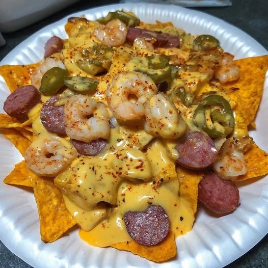 Delicious spicy shrimp and sausage nachos topped with cheese and jalapeños