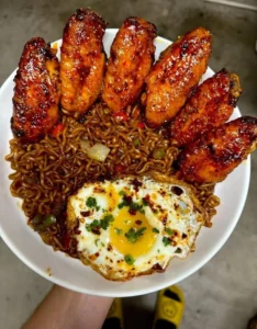 Delicious spicy wings served with a black bean noodle bowl