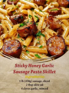 Sticky Honey Garlic Sausage Pasta Skillet in a pan garnished with herbs
