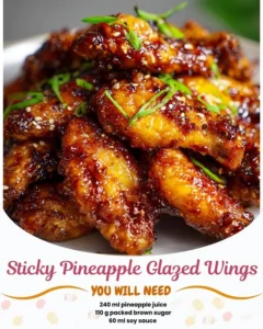 Sticky pineapple glazed wings on a plate garnished with fresh herbs