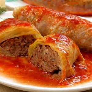 Plate of homemade stuffed cabbage rolls with herbs and sauce